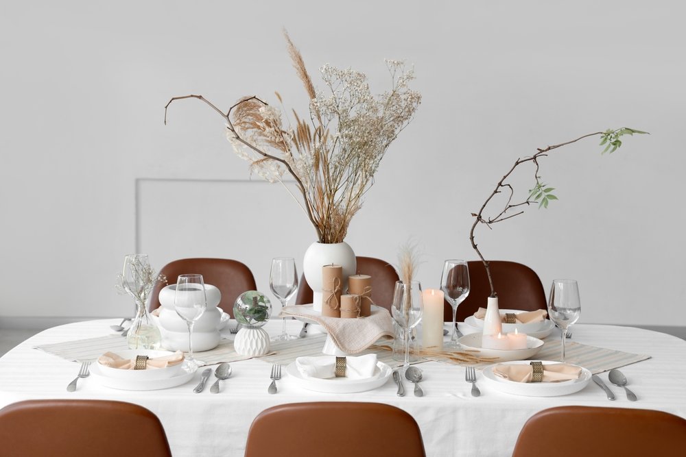 An elegant table with a tablecloth, dishes, & a floral centerpiece